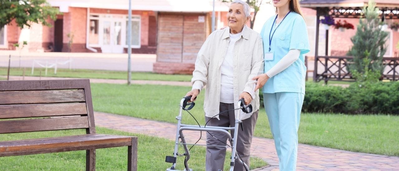 Care worker assisting an individual with mobility and recovery exercises at home to regain independence.